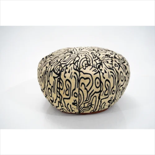 Pouf artigianale nero e beige con motivi intricati