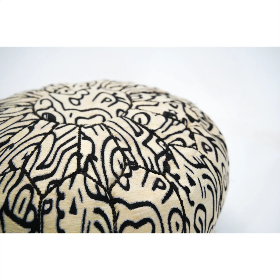 Pouf artigianale nero e beige con motivi intricati