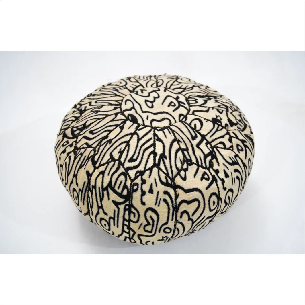 Pouf artigianale nero e beige con motivi intricati