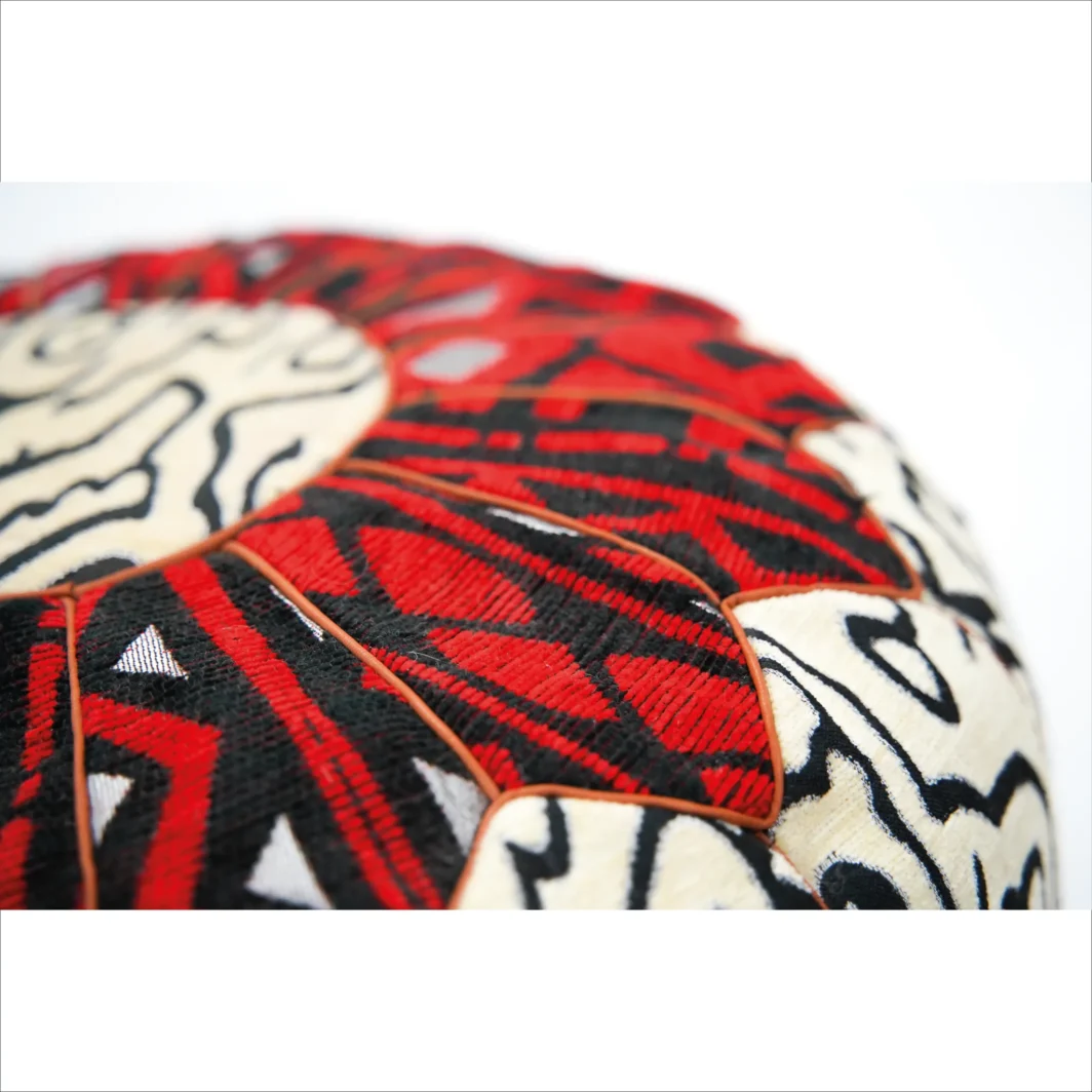 Puf artesanal rojo y negro con diseño tribal